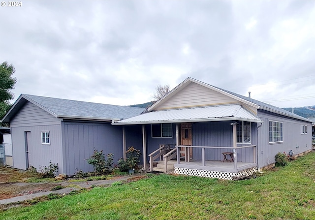 view of front of house with covered porch and a front lawn