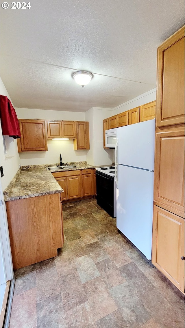 kitchen featuring sink, white appliances, a textured ceiling, and light stone counters