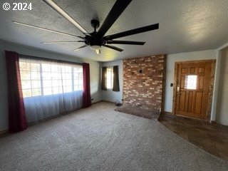 unfurnished living room with carpet floors and ceiling fan