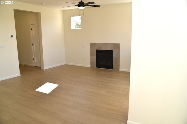 unfurnished living room with a fireplace, light wood-type flooring, and ceiling fan