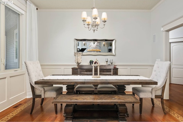 dining space featuring a decorative wall, a notable chandelier, wood finished floors, and ornamental molding