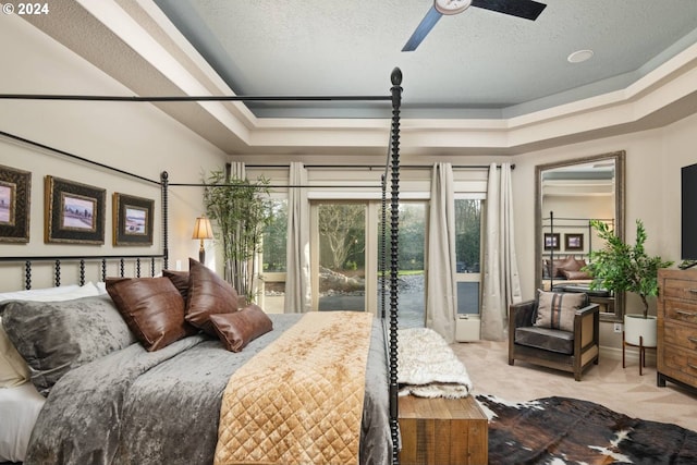 carpeted bedroom featuring a textured ceiling and a raised ceiling