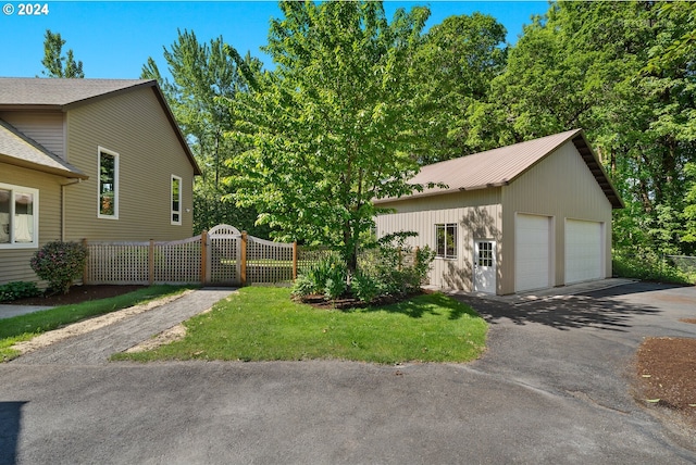 view of front of property with an outbuilding, a detached garage, and fence