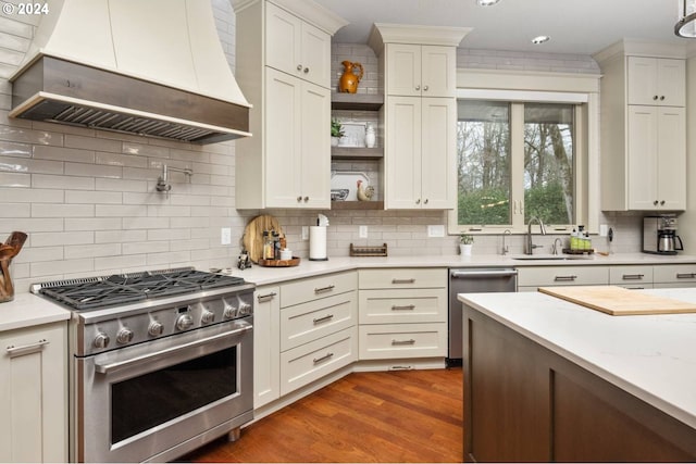 kitchen featuring open shelves, wood finished floors, appliances with stainless steel finishes, light countertops, and custom exhaust hood