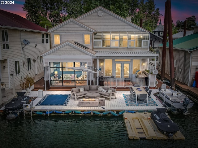 back house at dusk featuring french doors and an outdoor hangout area