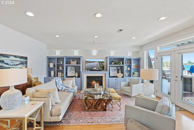 living room featuring a textured ceiling and light wood-type flooring