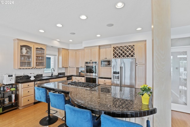 kitchen featuring sink, appliances with stainless steel finishes, light hardwood / wood-style flooring, and light brown cabinets