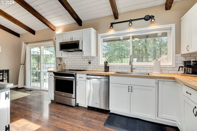 kitchen with butcher block counters, backsplash, stainless steel appliances, white cabinetry, and sink