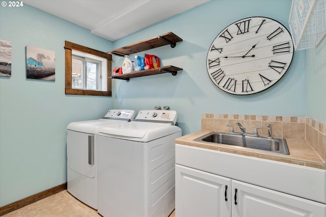 clothes washing area featuring light tile floors, cabinets, separate washer and dryer, and sink