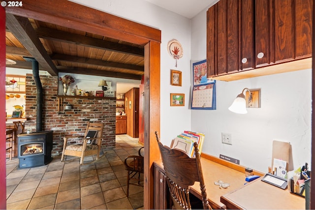 dining room with tile patterned flooring, beam ceiling, a wood stove, and wooden ceiling