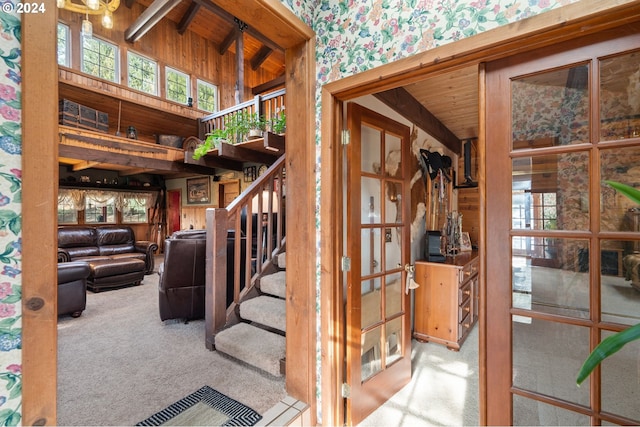 stairs featuring beamed ceiling, carpet flooring, and a high ceiling