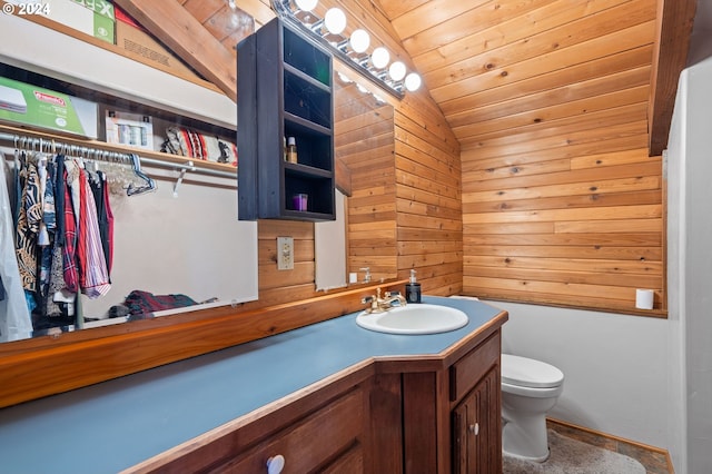 bathroom featuring lofted ceiling, wooden walls, wooden ceiling, vanity, and toilet