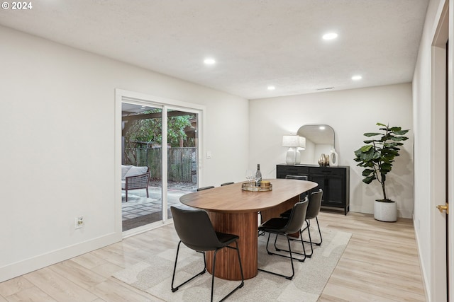 dining area featuring a textured ceiling and light hardwood / wood-style flooring