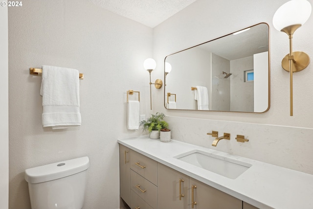 bathroom featuring vanity, a textured ceiling, and toilet