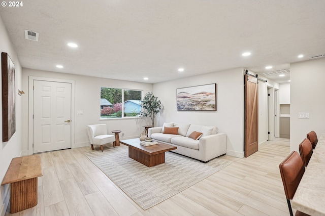 living room featuring a barn door and light hardwood / wood-style floors