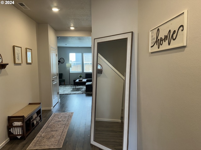 hallway featuring dark hardwood / wood-style flooring and a textured ceiling