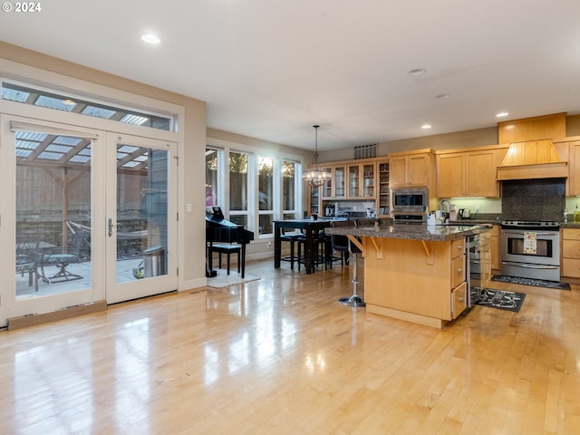 kitchen with a breakfast bar, a center island, stainless steel appliances, and a wealth of natural light