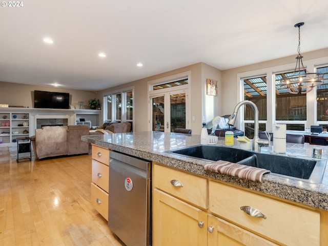 kitchen featuring sink, light hardwood / wood-style flooring, stainless steel dishwasher, a notable chandelier, and light brown cabinetry