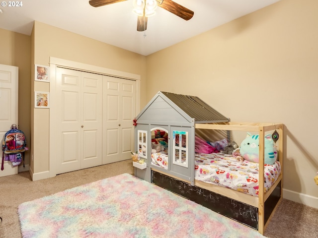 carpeted bedroom featuring ceiling fan and a closet