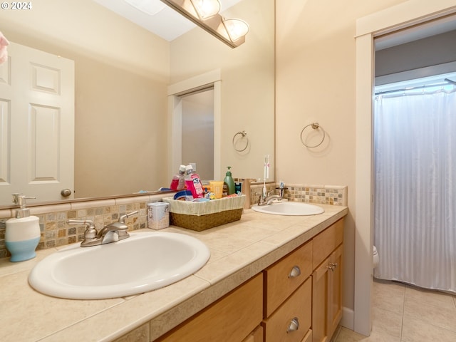 bathroom featuring tile patterned floors, vanity, and decorative backsplash