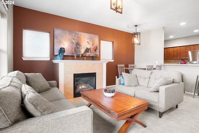 living room featuring a tiled fireplace and light carpet