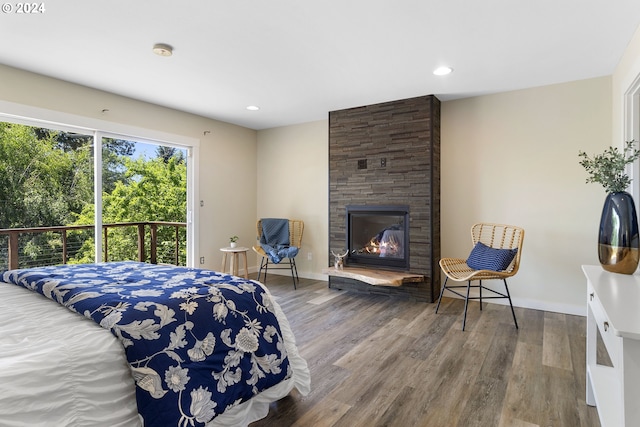 bedroom with hardwood / wood-style floors and a fireplace