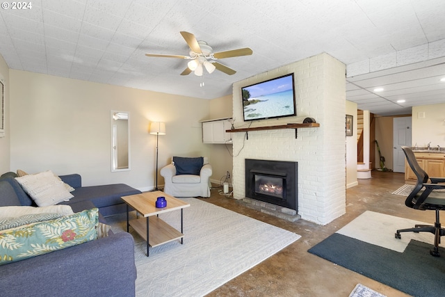 living room with ceiling fan, sink, concrete flooring, and a fireplace