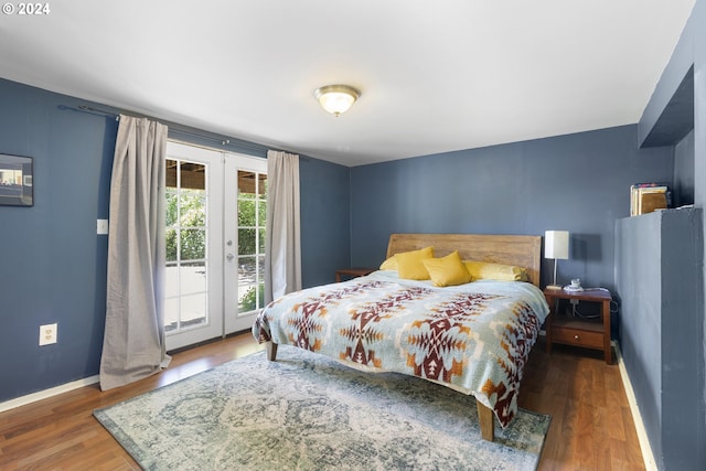 bedroom featuring dark hardwood / wood-style flooring, access to outside, and french doors