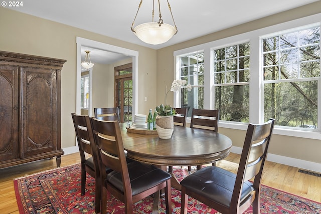 dining space featuring light wood-type flooring and a healthy amount of sunlight