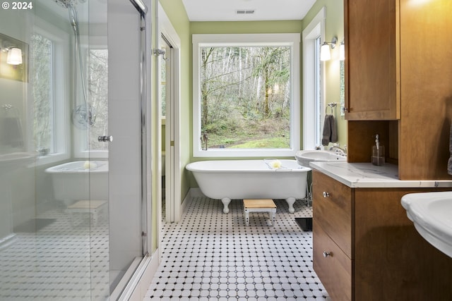 bathroom featuring shower with separate bathtub, oversized vanity, tile flooring, and a wealth of natural light