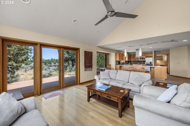 living room featuring ceiling fan, high vaulted ceiling, a healthy amount of sunlight, and light hardwood / wood-style floors