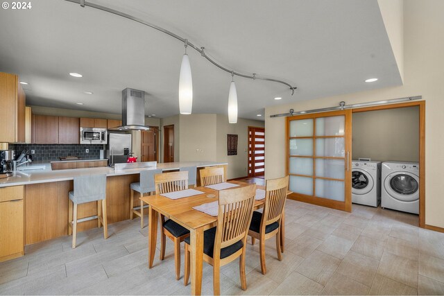kitchen with backsplash, island range hood, appliances with stainless steel finishes, light countertops, and a peninsula