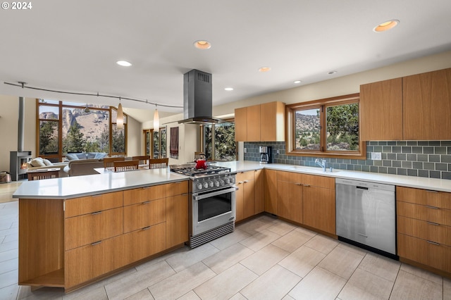 kitchen featuring sink, kitchen peninsula, decorative backsplash, island range hood, and appliances with stainless steel finishes