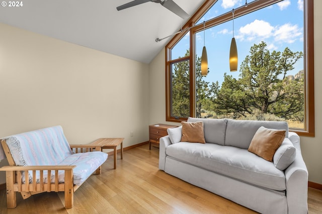 living room featuring visible vents, baseboards, high vaulted ceiling, a ceiling fan, and light wood finished floors