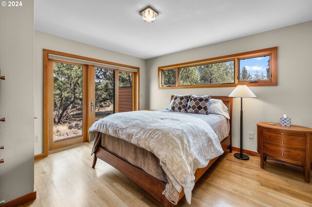 bedroom featuring baseboards, access to exterior, and light wood finished floors