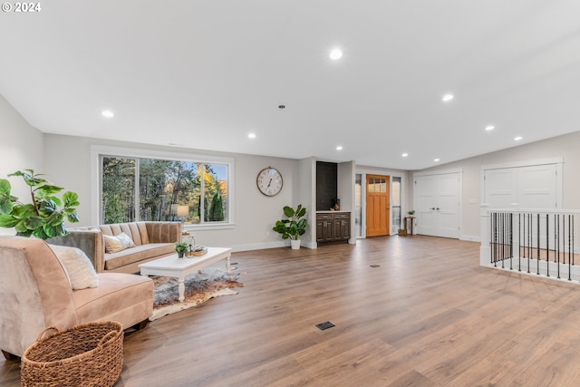 living room with wood-type flooring and lofted ceiling