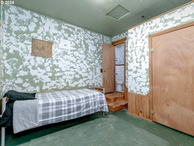 bedroom with wallpapered walls, attic access, and connected bathroom