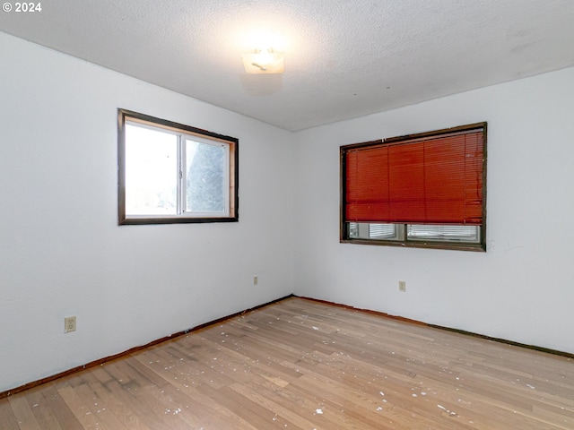 spare room with light wood-style flooring and a textured ceiling