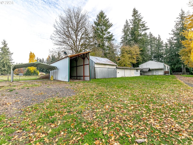 view of yard featuring a carport and a pole building