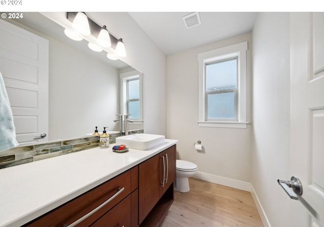 bathroom with vanity, toilet, and hardwood / wood-style floors