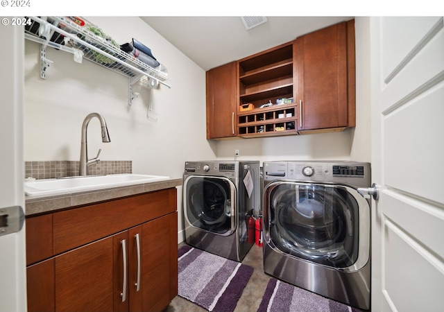 washroom with sink, cabinets, and washer and clothes dryer