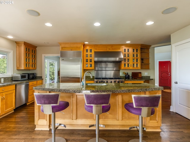 kitchen featuring an island with sink, a kitchen bar, sink, and stainless steel appliances