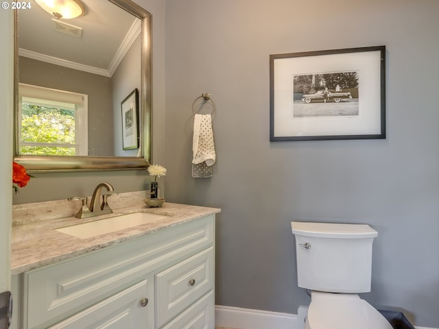 bathroom with vanity, crown molding, and toilet