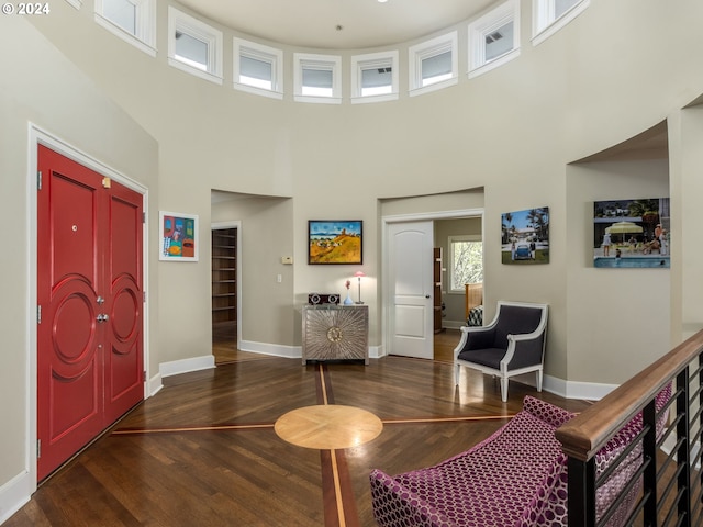 interior space featuring a towering ceiling and dark hardwood / wood-style floors