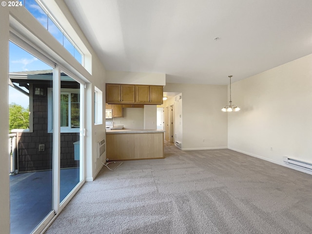 kitchen featuring a notable chandelier, kitchen peninsula, decorative light fixtures, and light carpet