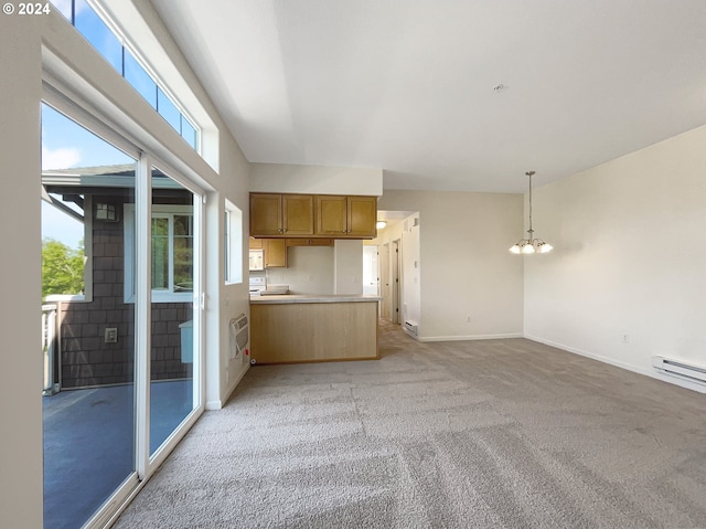 interior space featuring kitchen peninsula, a wealth of natural light, pendant lighting, and light colored carpet