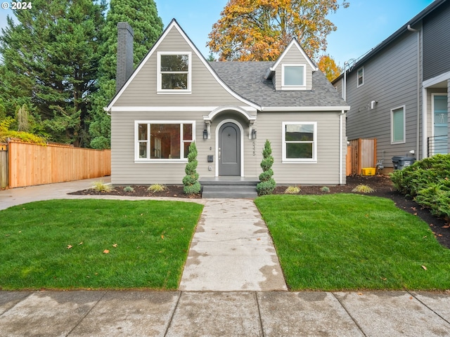 cape cod-style house featuring a front lawn