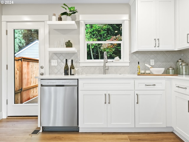 bar featuring sink, white cabinetry, light hardwood / wood-style floors, stainless steel dishwasher, and decorative backsplash