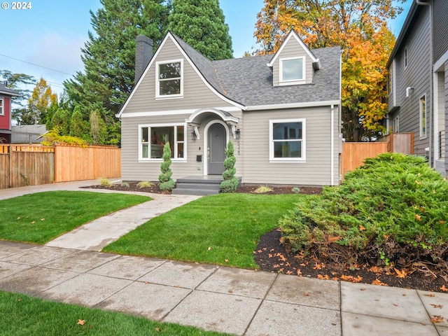 cape cod house with a front yard