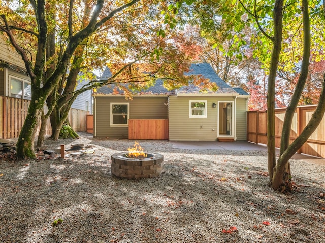 back of house with an outdoor fire pit and a patio area